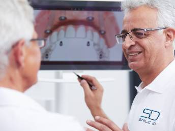 Nasser Assadi erklärt einem Patienten den Behandlungsablauf anhand eines digitalen Models