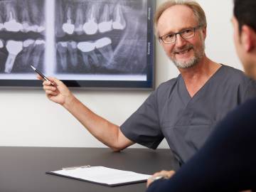 Arzt mit Patient in der Röntgenbildbesprechung